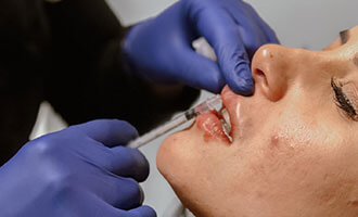 Woman getting a lip filler injection at MediZen Institute