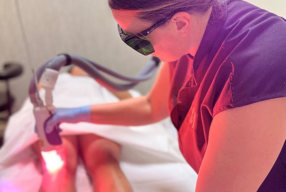 woman in violet doing laser skin treatment